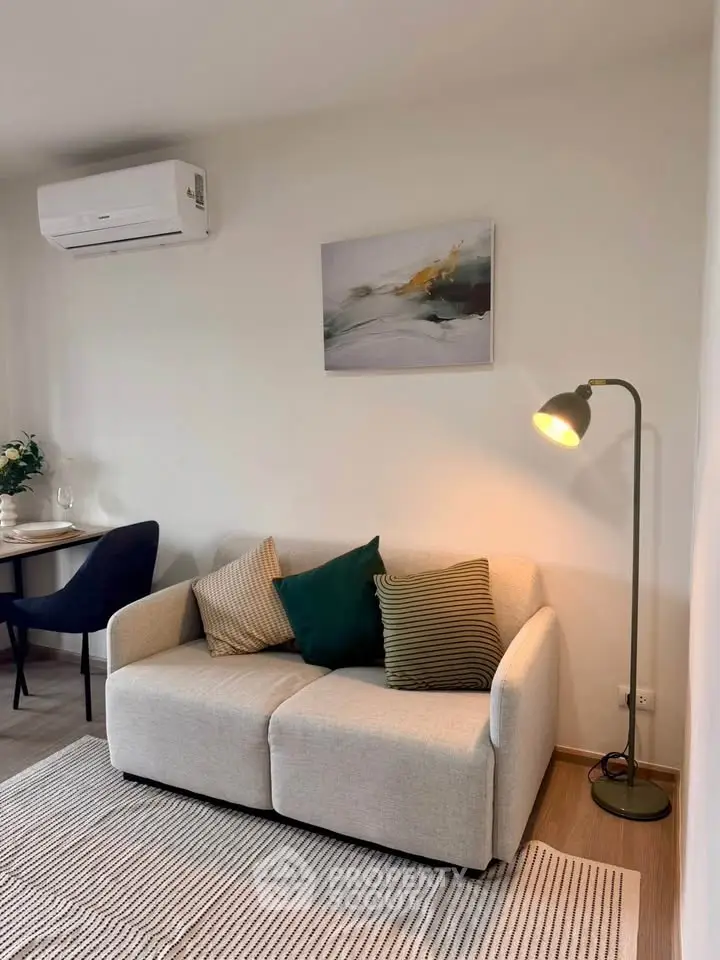 Cozy living room with modern sofa, stylish floor lamp, and elegant wall art, perfect for relaxation.