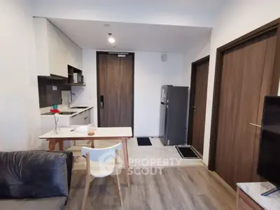 Modern open-plan living room with kitchen and dining area, featuring sleek furniture and contemporary design.