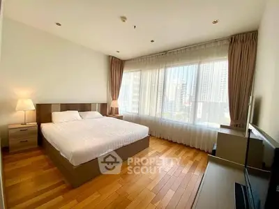 Spacious bedroom with city view, wooden flooring, and modern furnishings.