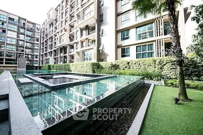 Modern apartment complex with luxurious pool and lush greenery