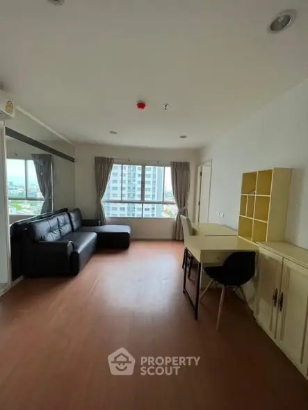 Spacious living room with modern decor and large windows offering city views.