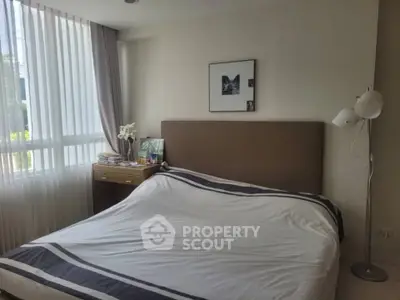 Cozy bedroom with modern decor and natural light, featuring a stylish bed and elegant curtains.