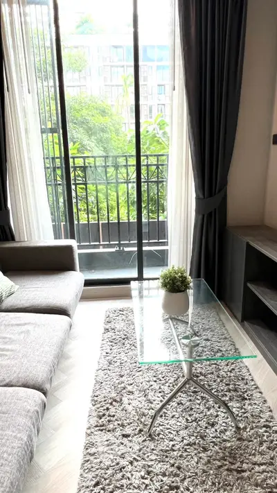 Modern living room with glass coffee table and balcony view