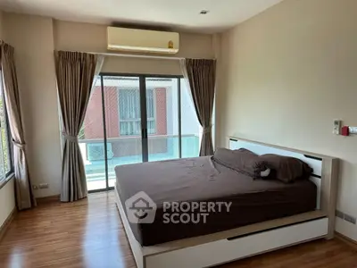 Spacious bedroom with large windows and modern decor in a stylish apartment.