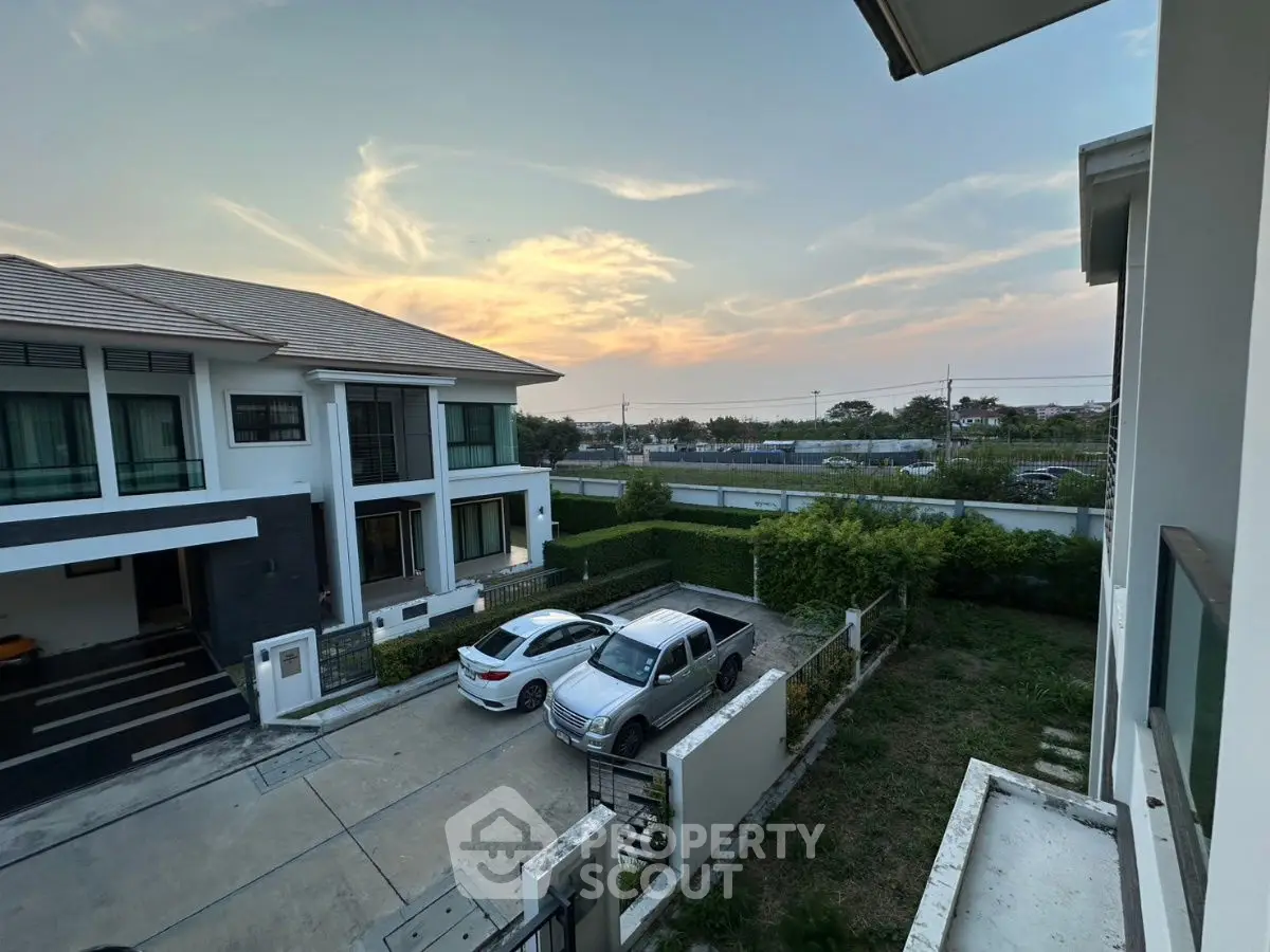 Charming suburban home with spacious driveway and scenic sunset view.