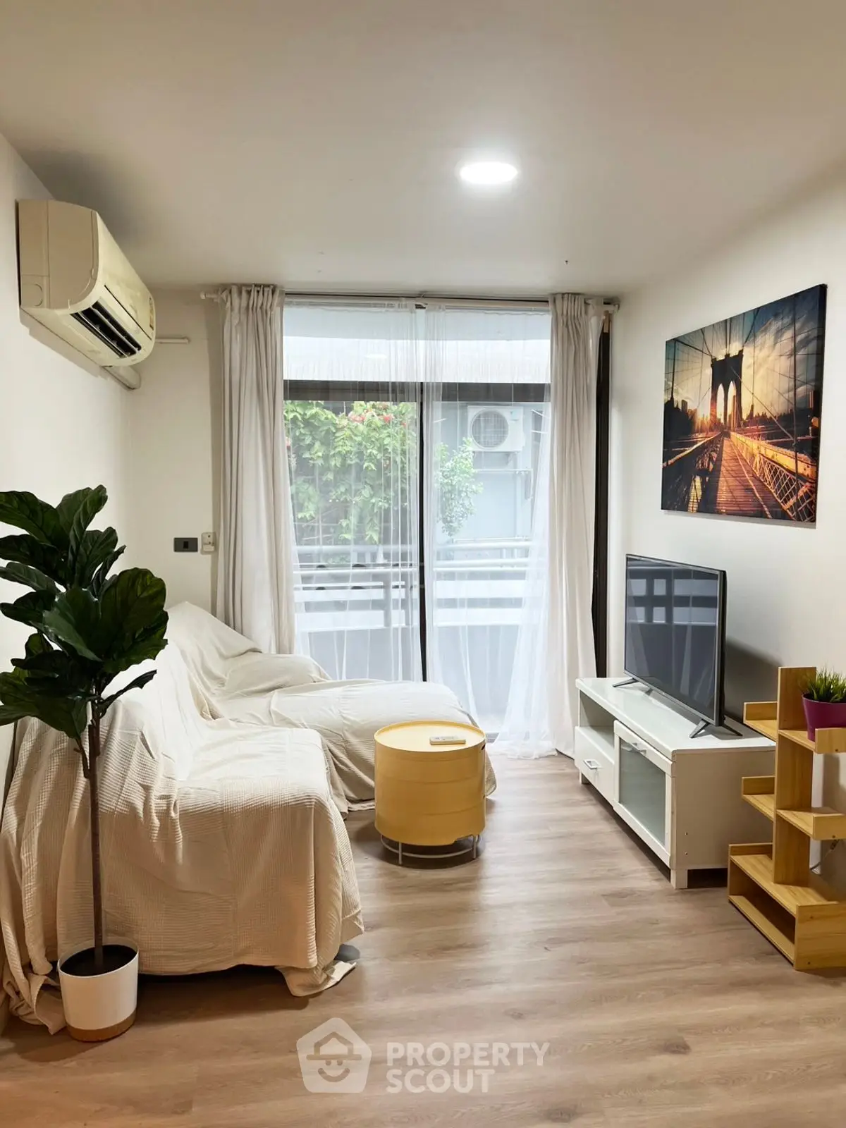 Modern living room with cozy sofa, TV, and large window view