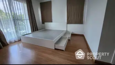 Spacious bedroom with large windows and wooden flooring, perfect for natural light lovers.