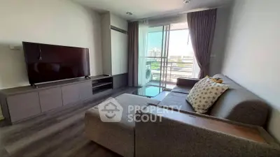 Modern living room with large TV and balcony view in stylish apartment