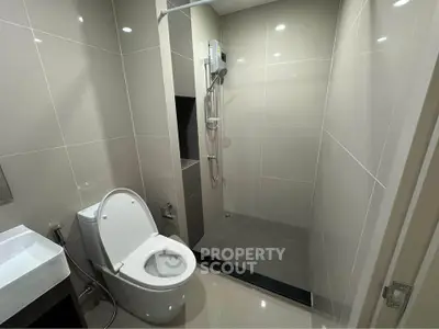 Modern bathroom with sleek shower and toilet in contemporary design.