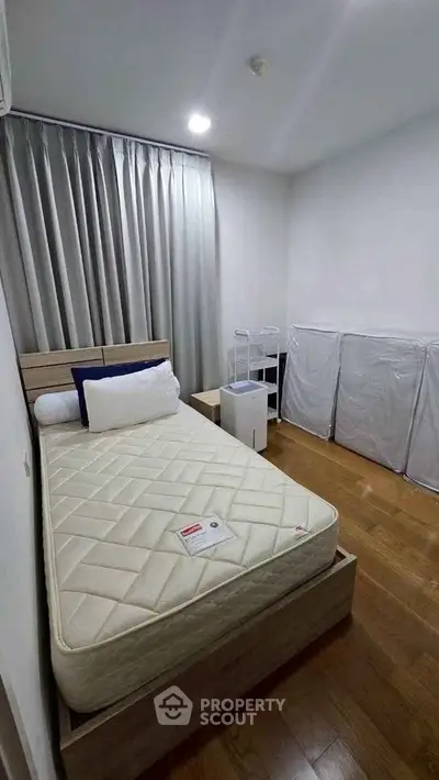 Cozy bedroom with wooden flooring and modern furnishings, perfect for a restful retreat.