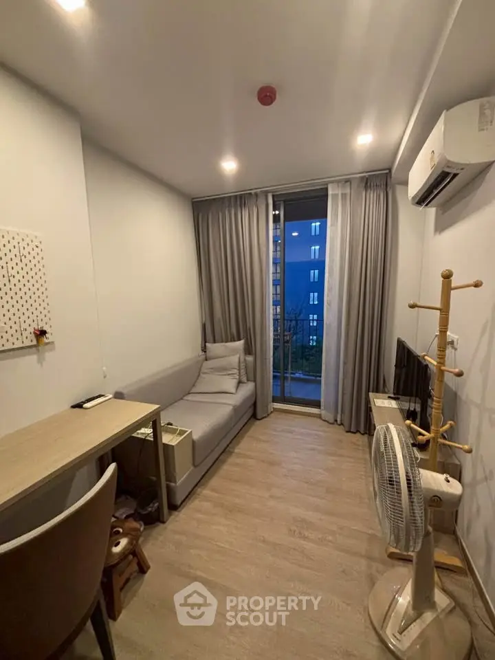Cozy modern living room with balcony access and air conditioning