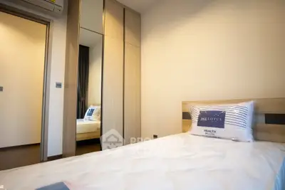 Modern bedroom with mirrored wardrobe and cozy bedding in a stylish apartment.