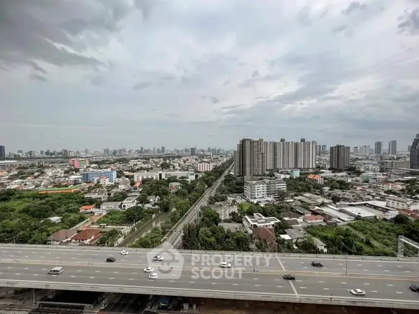 Stunning cityscape view from high-rise building overlooking urban skyline and highway.