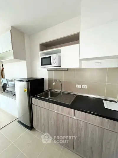 Modern kitchen with sleek cabinetry and stainless steel appliances in a contemporary apartment.