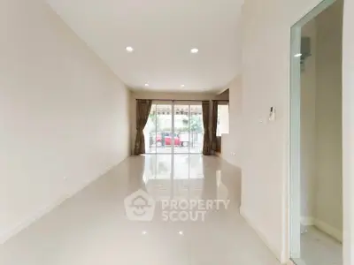 Spacious empty living room with large windows and bright natural light