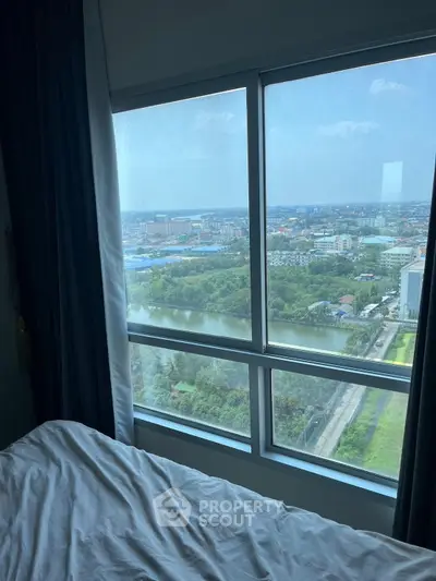 Stunning high-rise bedroom view with expansive cityscape and river scenery.