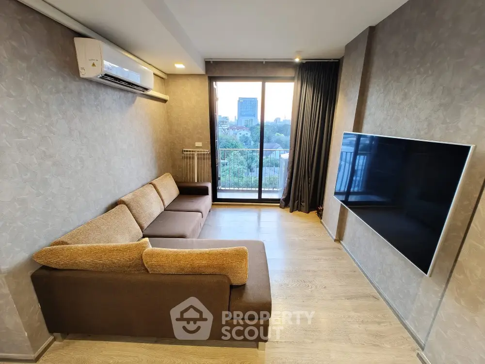 Modern living room with large TV and city view balcony