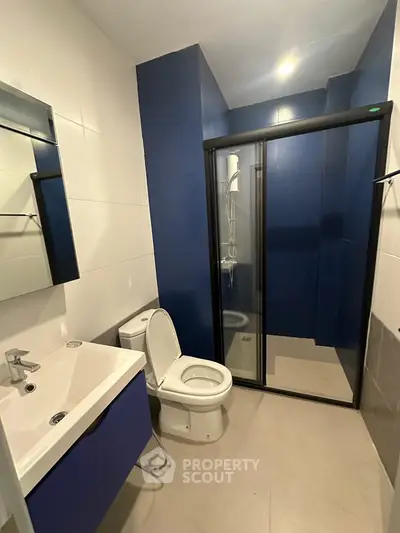 Modern bathroom with sleek blue accents and glass shower enclosure