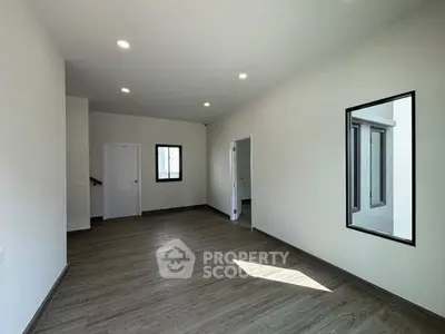 Spacious modern living room with large windows and wood flooring