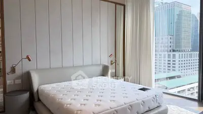 Luxurious bedroom with modern design and stunning city view through large windows.