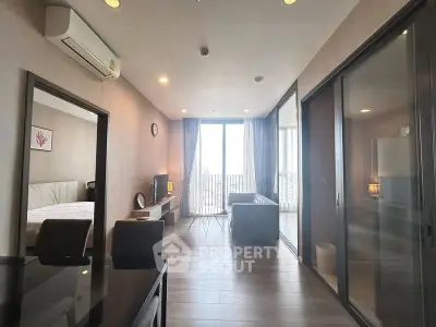 Modern living room with large windows and stylish furniture in a high-rise apartment.