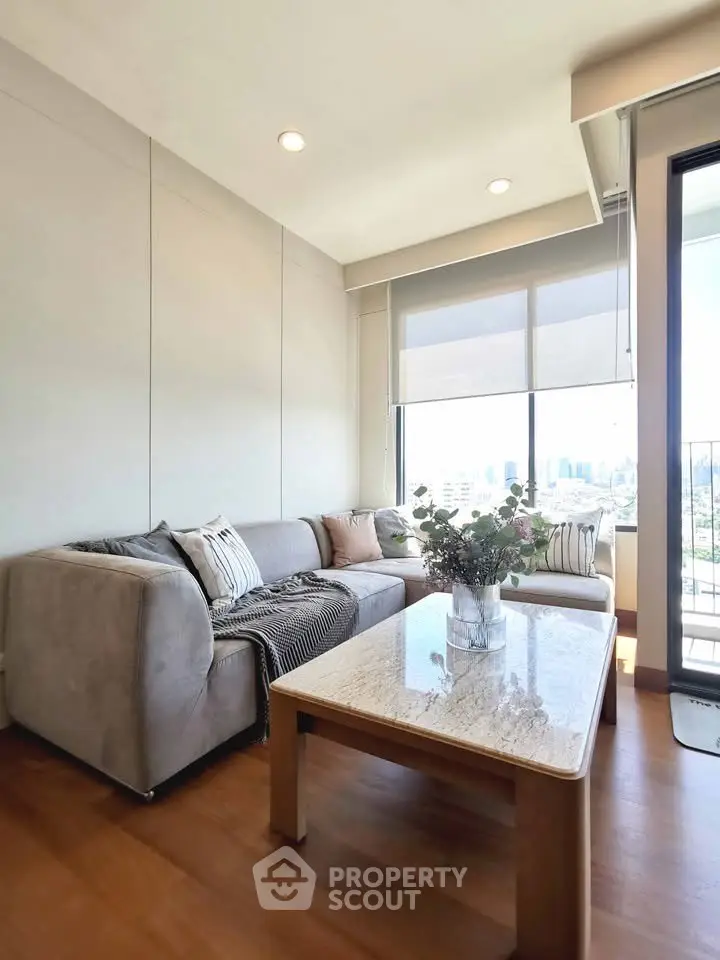 Modern living room with cozy sofa and city view from large windows