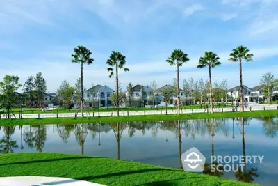 Stunning lakeside view with modern homes and palm trees reflecting in the water.