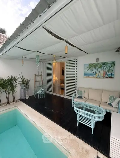 Charming poolside patio with cozy seating and tropical decor, perfect for relaxation and entertaining.