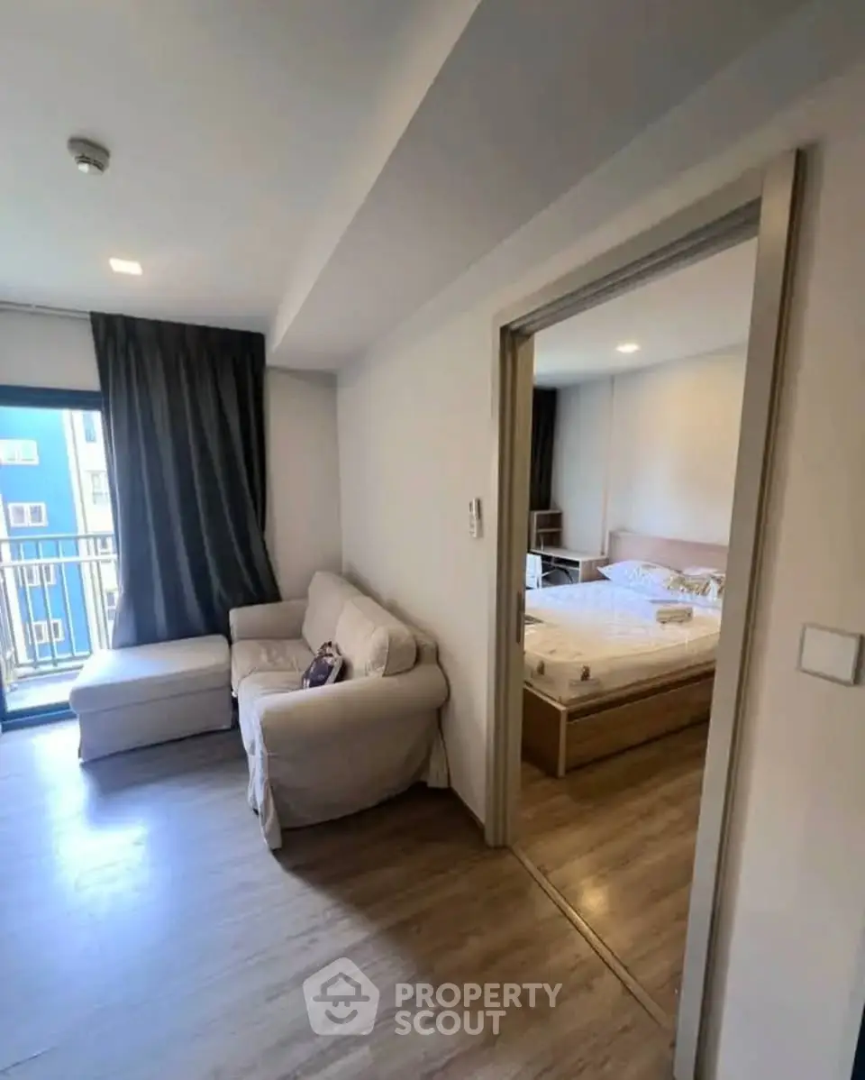 Cozy apartment with living room and bedroom, featuring a small balcony and modern decor.