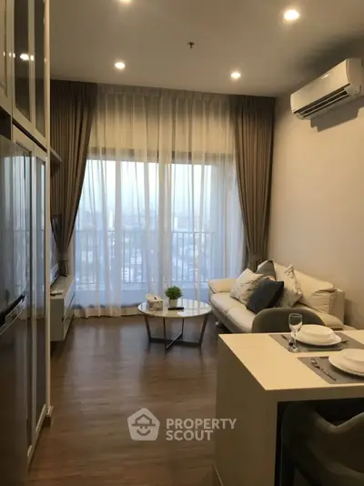 Modern living room with large windows and elegant decor in a high-rise apartment.