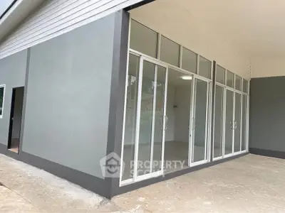 Modern commercial space with large glass doors and sleek exterior design.