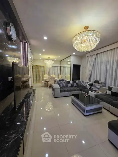 Luxurious living room with elegant chandeliers and modern furnishings in a spacious open layout.