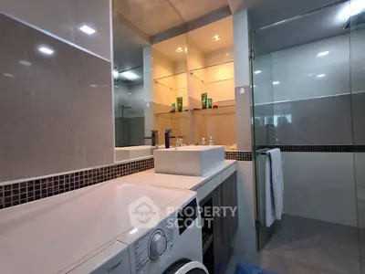 Modern bathroom with washing machine and glass shower enclosure