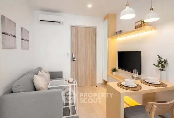 Modern living room with cozy seating and stylish decor in a compact apartment.