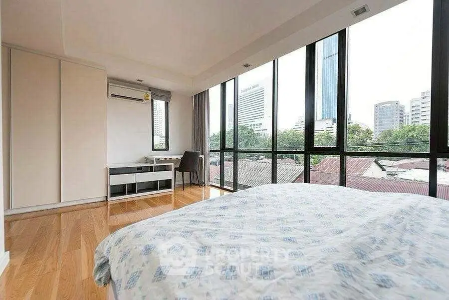 Spacious bedroom with city view and modern furnishings