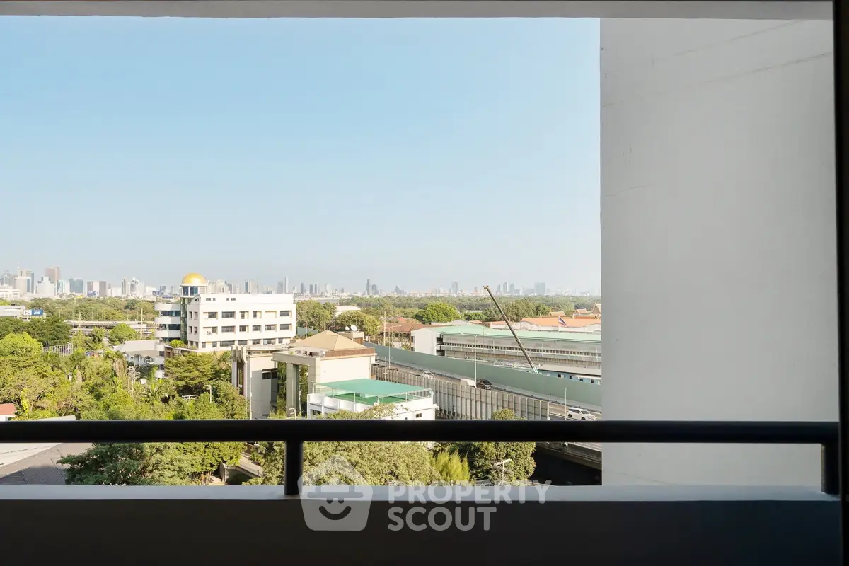 Stunning cityscape view from a balcony showcasing urban skyline and greenery.