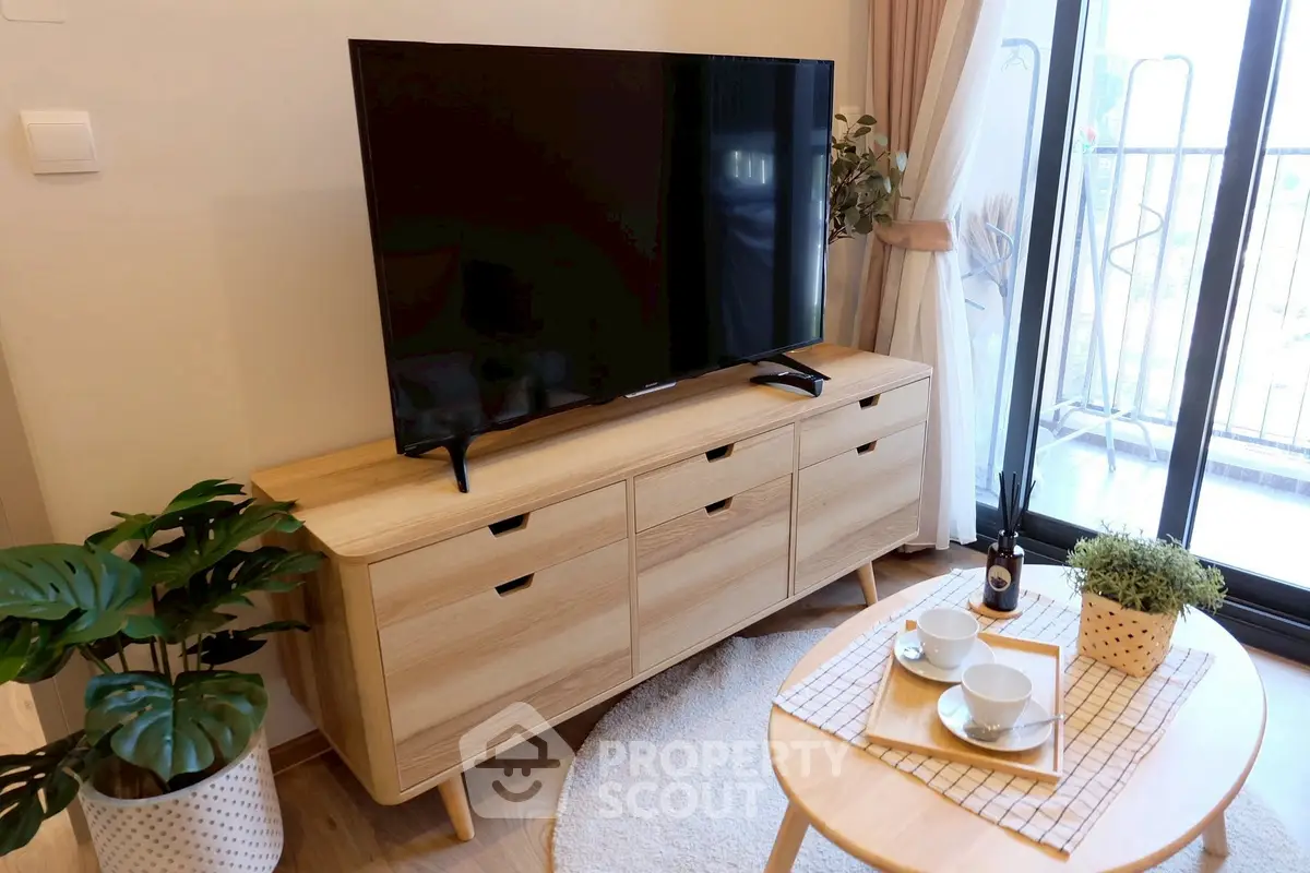 Stylish living room with modern TV setup and balcony view, perfect for relaxation and entertainment.