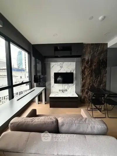 Modern living room with stylish marble TV wall and large windows offering city views.