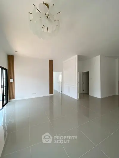 Spacious modern living room with elegant chandelier and sleek tile flooring