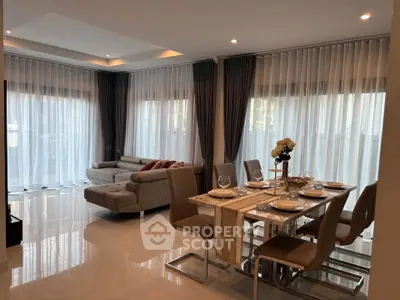 Elegant living and dining area with modern furniture and large windows for natural light.