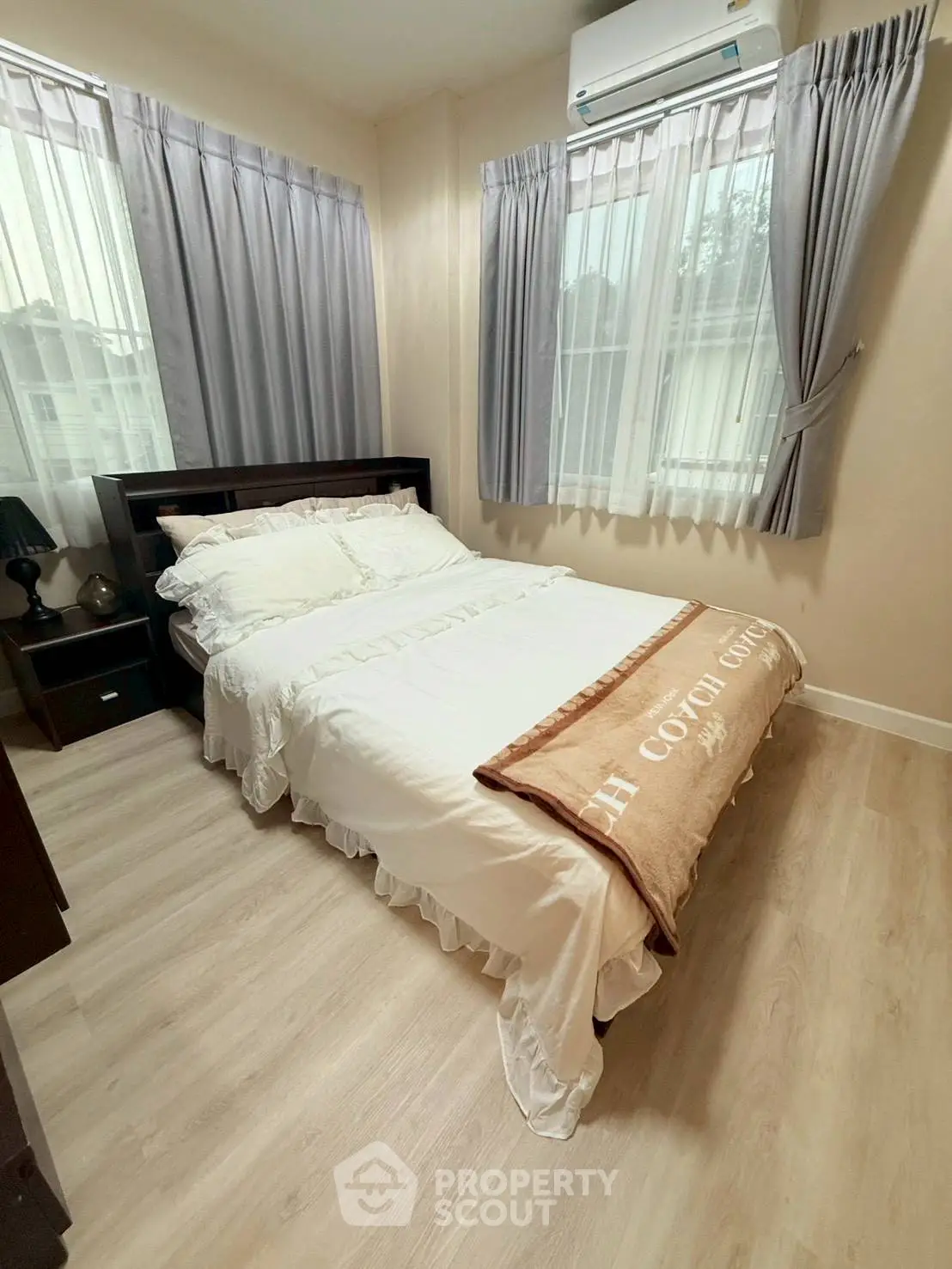 Cozy bedroom with natural light, featuring a comfortable bed and elegant curtains, perfect for relaxation.