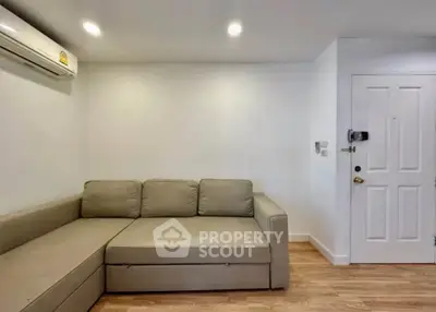 Modern living room with beige sectional sofa and air conditioning in a minimalist design.