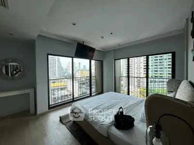 Modern bedroom with city view and large windows in urban apartment
