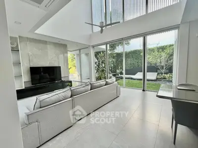 Spacious modern living room with garden view and sleek interior design.
