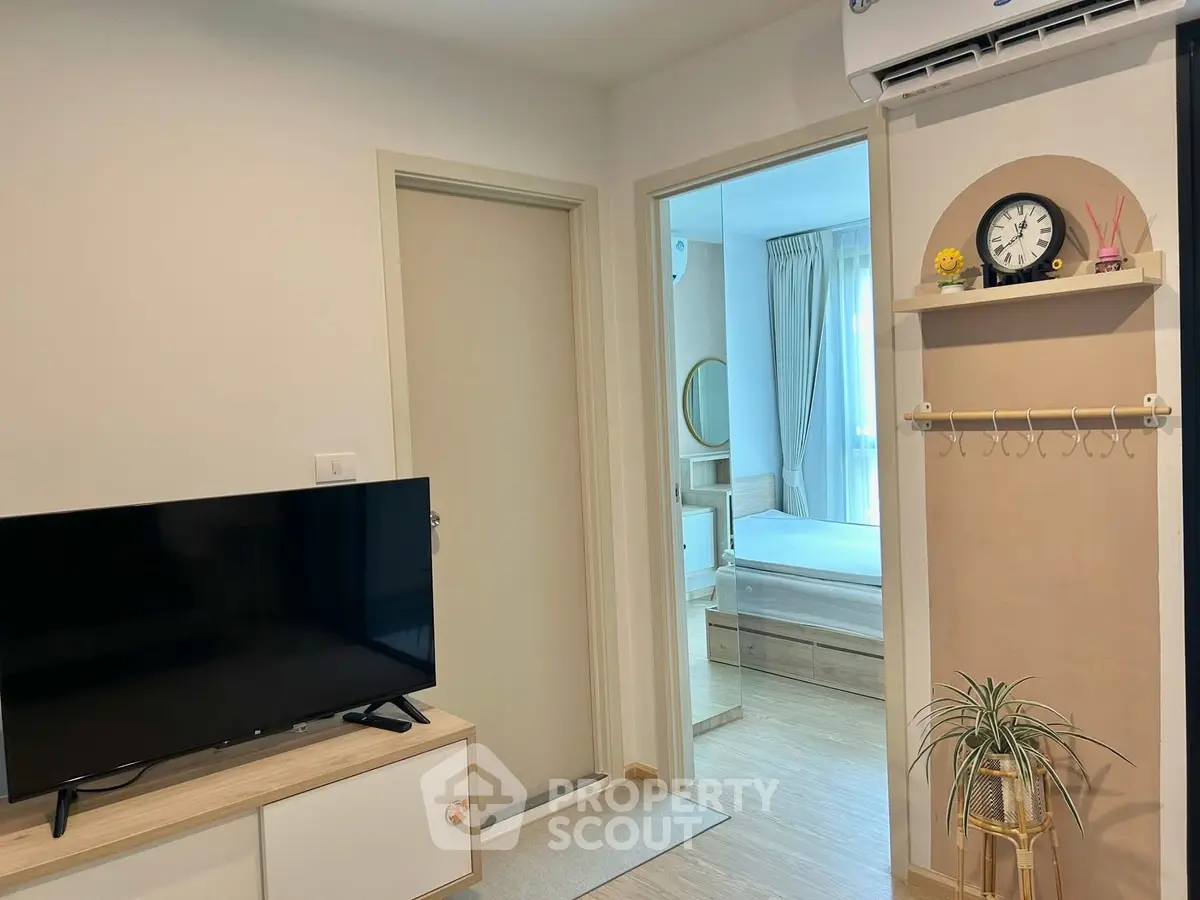 Modern apartment interior with TV and cozy bedroom view, featuring stylish decor and air conditioning.