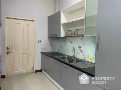 Modern kitchen with sleek cabinetry and dual sinks in a compact layout.