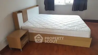Spacious bedroom with modern wooden bed and natural light