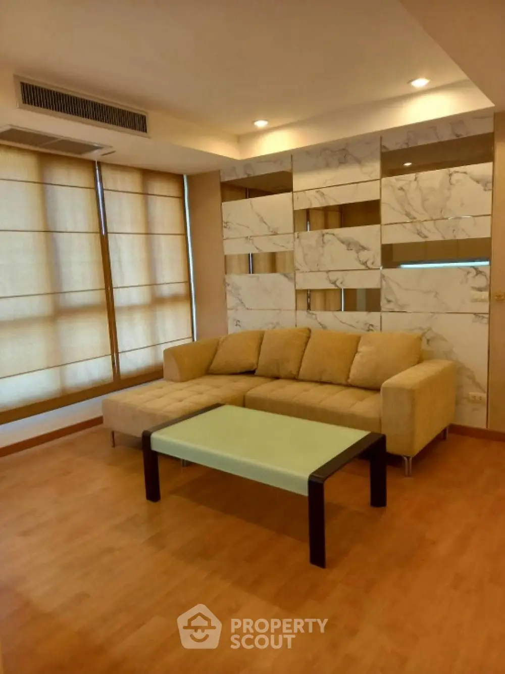 Modern living room with stylish sofa and marble accent wall