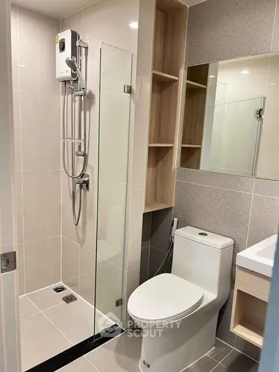 Modern bathroom with glass shower and sleek fixtures in contemporary apartment.