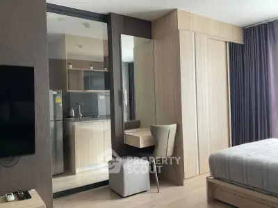Modern studio apartment with sleek kitchen and cozy bedroom area, perfect for urban living.